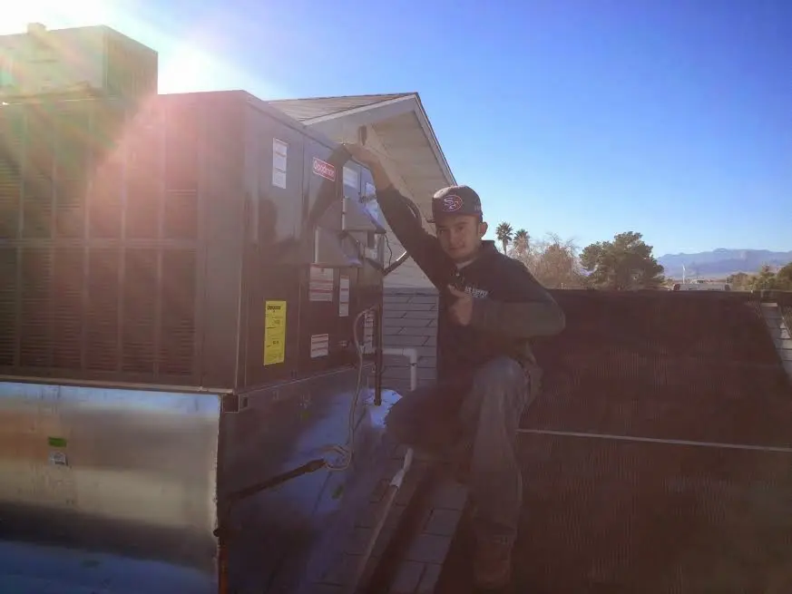 HVAC technician performing Heat Pump Repair on a rooftop unit in Eastpointe